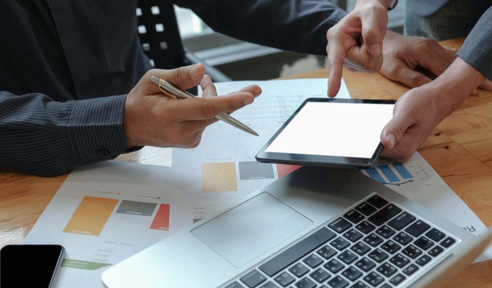 Male businessteam hands work on calculator and tablet in the office.They analyze the work to achieve the goal.